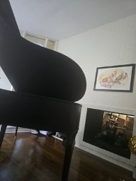 Teresa’s grand piano at home, beside a fireplace